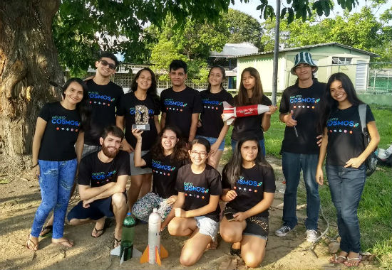 Na foto, integrantes do Projeto Cosmos fazem pose para foto. Os jovens seguram algumas miniaturas de foguetes.