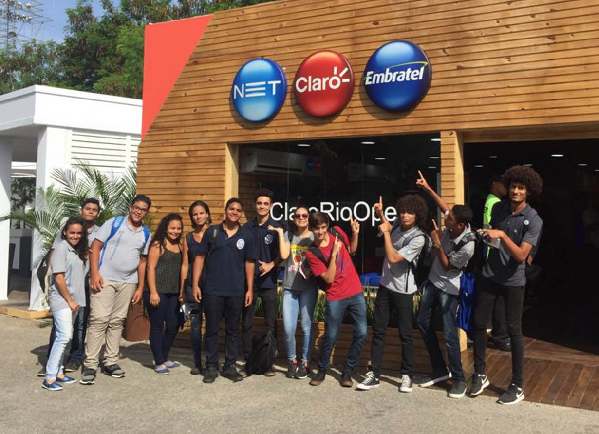 Foto de um grupo de jovens posando para uma foto em frente a um estande do Instituto Claro durante o Rio Open 2018