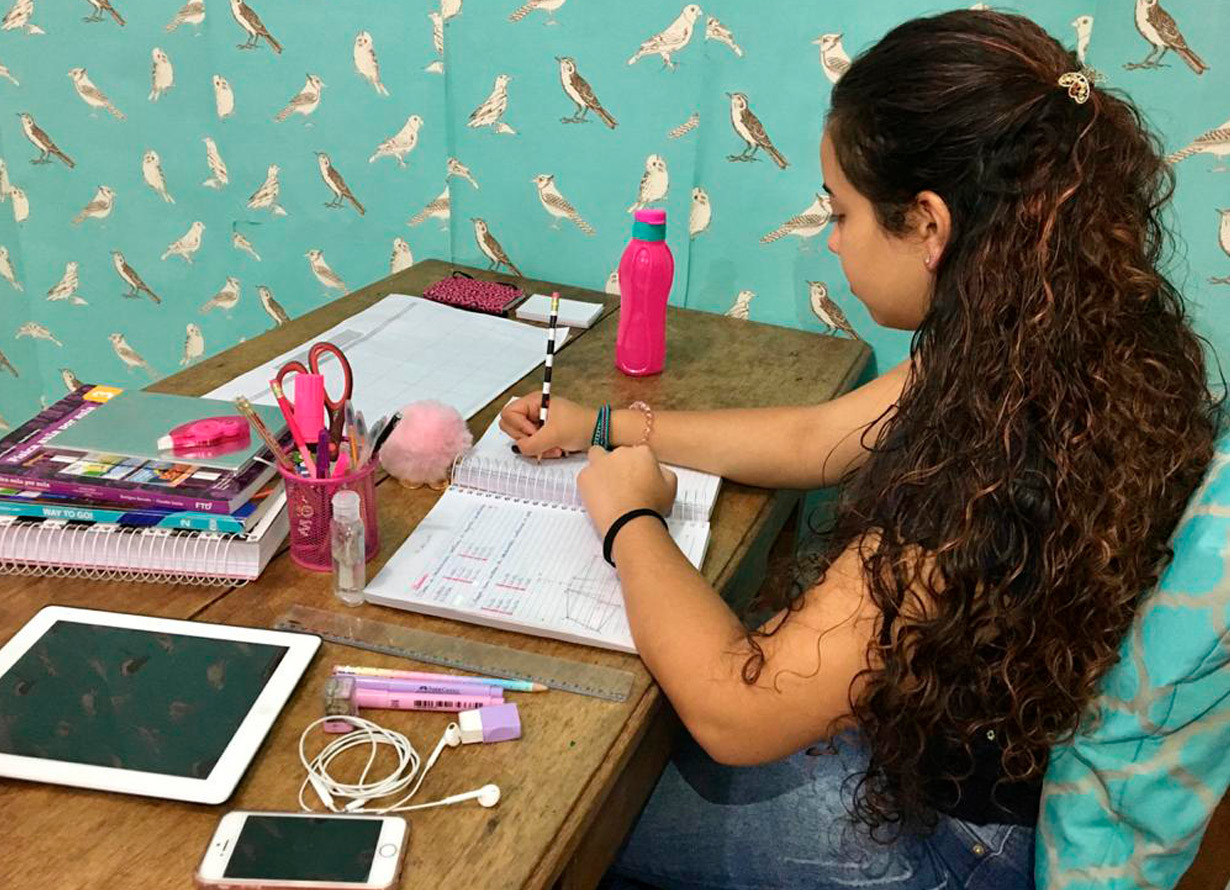 Foto de uma garota estudando em uma escrivaninha