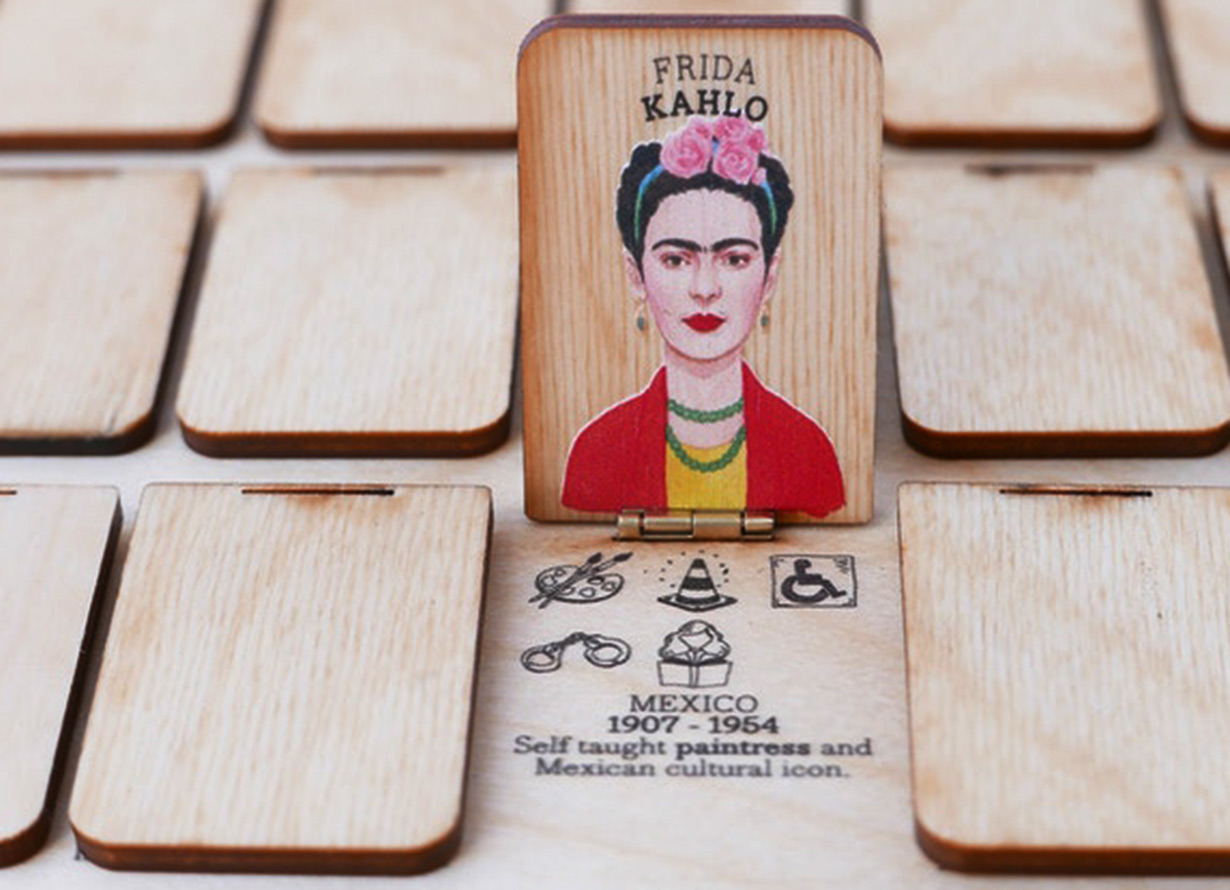 Foto do jogo who's she, com a figura de Frida Kahlo em um tabuleiro de madeira